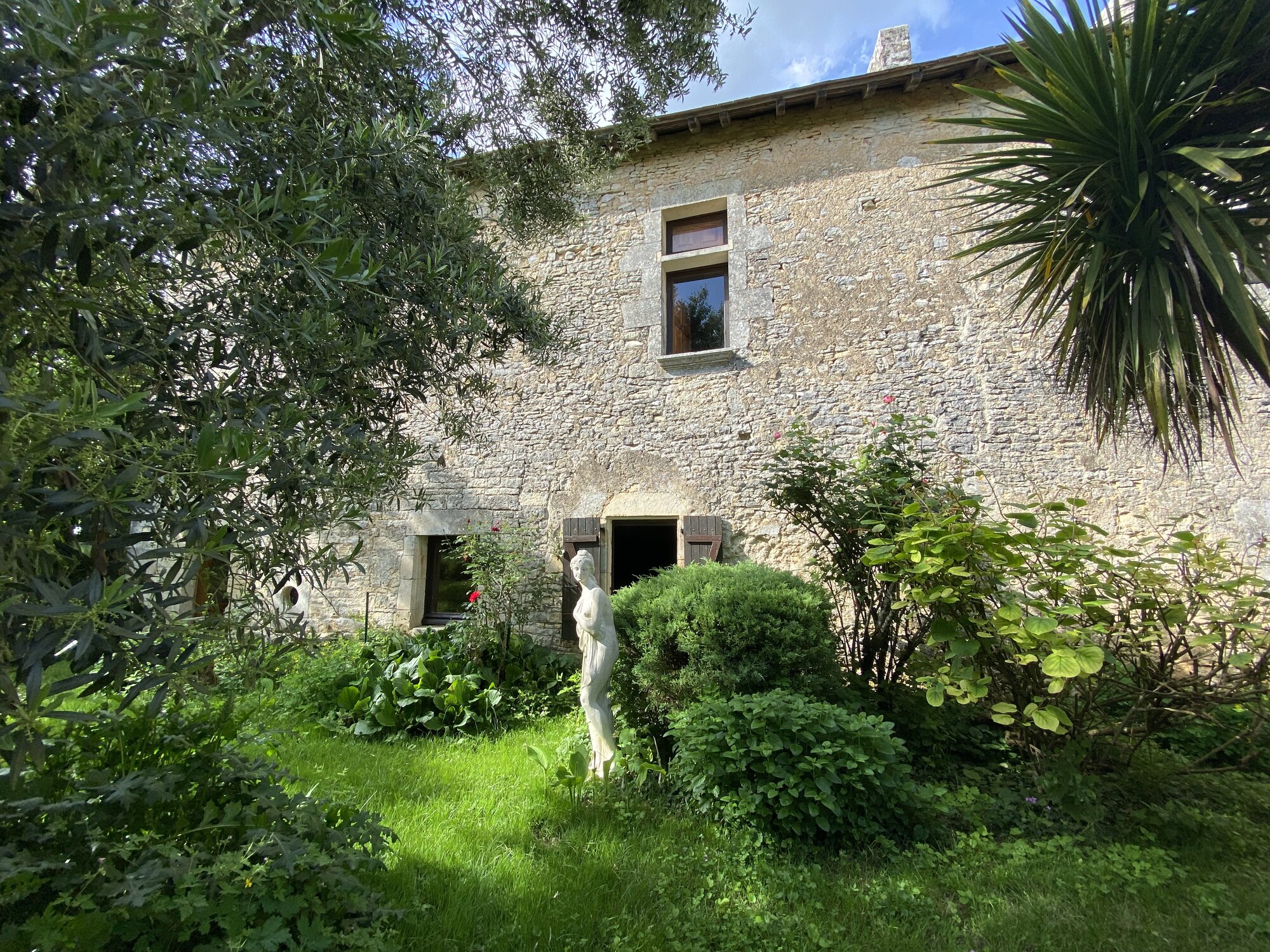 Vue du jardin et façade du manoir La Maison Noble
