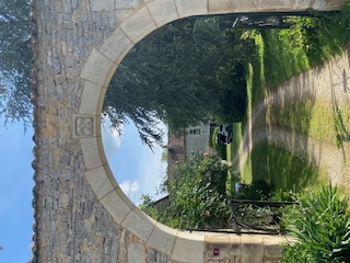 Porche en arc de pierre ouvrant sur le manoir