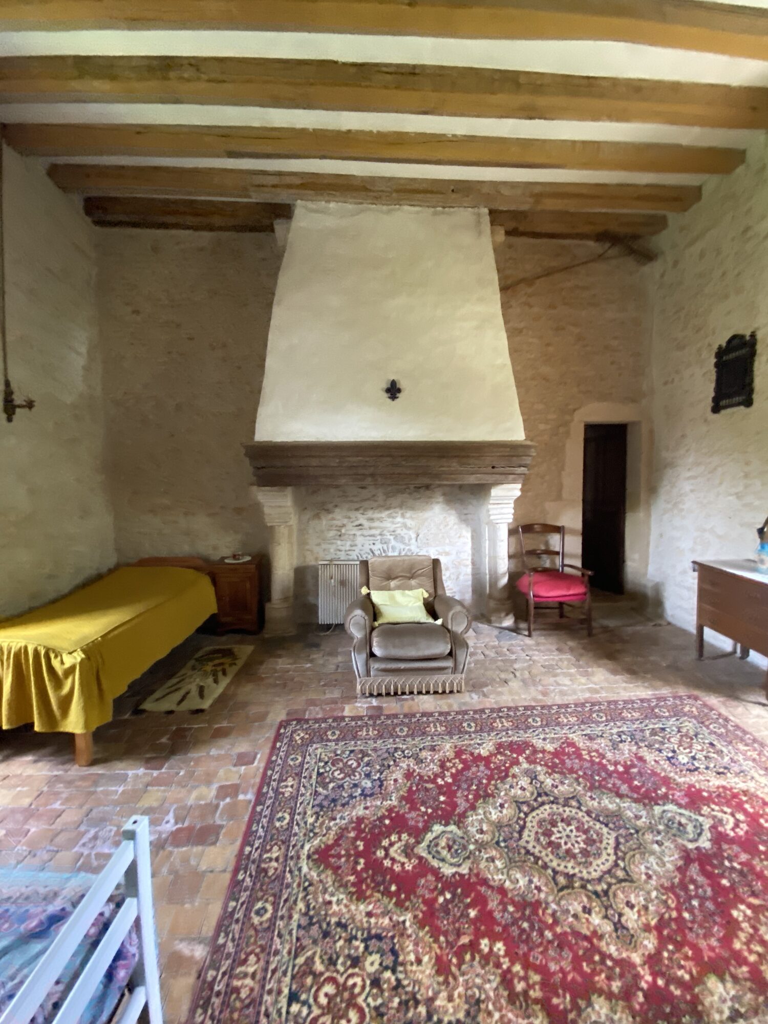 Grand dortoir d'époque avec cheminée monumentale et fleur de lys